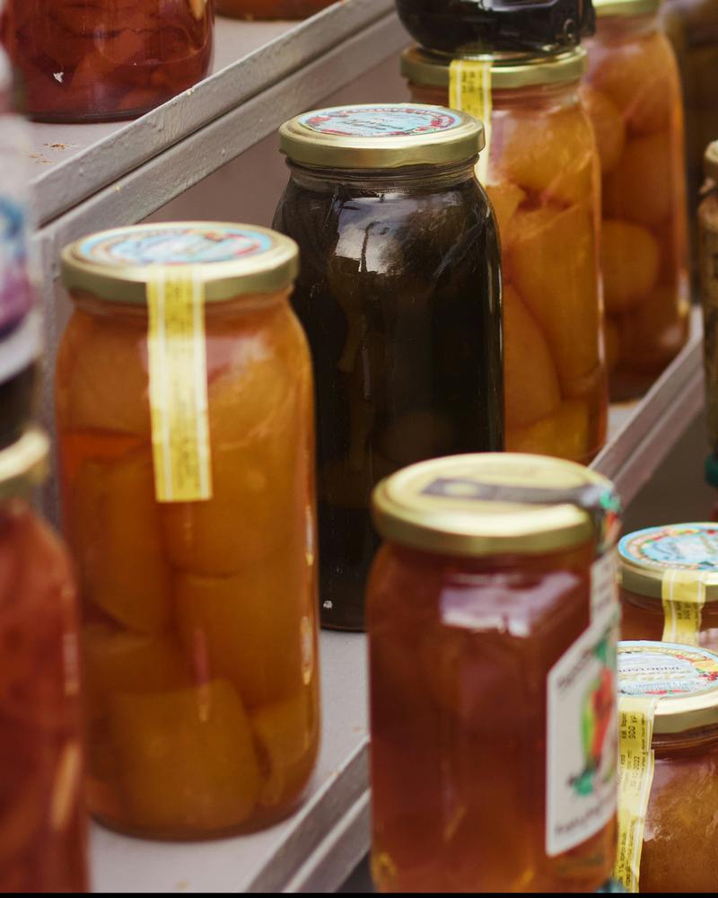 Jars of homemade preserves on a shelf, with a Jarrito label